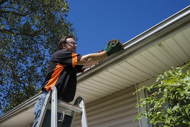 a gutter repair specialist working on a broken downspout in East Syracuse